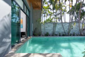 a swimming pool in a house with palm trees at Onyx Villas by TropicLook in Nai Harn Beach