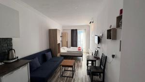 Gudauri loft Apartments #417 في Kʼumlistsʼikhe: غرفة معيشة مع أريكة زرقاء وطاولة