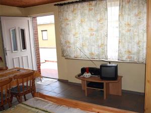 een kamer met een tafel, een tv en een raam bij kleines Ferienhaus am idyllischen Tüzer See 