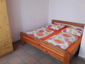 een slaapkamer met een houten bed met bloemen erop bij kleines Ferienhaus am idyllischen Tüzer See 