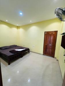 a bedroom with a bed and a wooden door at Leisure familyvillas in Padinjarathara