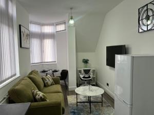 ein Wohnzimmer mit einem Sofa und einem TV in der Unterkunft Charming 1 bedroom Apartment In The Heart Of Manchester Close to Manchester City Centre And Etihad Stadium in Manchester