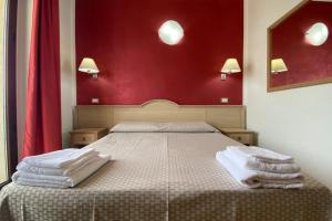 een slaapkamer met een bed met handdoeken erop bij B&B Marina Sleep And Ship in Rodi Garganico