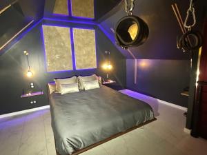 - une chambre violette avec un lit et une fenêtre dans l'établissement Insolite Escapade avec Spa privatif, à Pacy-sur-Eure