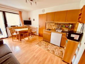 a kitchen and living room with a table and a kitchen and a dining room at Haus Hochhäusler in Schneizlreuth