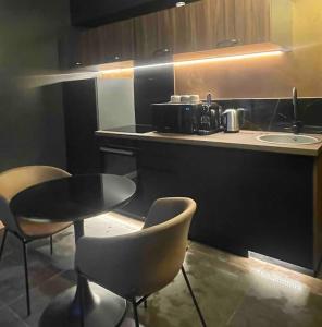 een keuken met een tafel en stoelen en een aanrecht bij Insolite Escapade avec Spa privatif in Pacy-sur-Eure