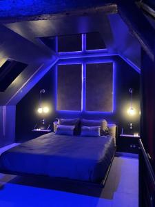 Cette chambre bleue comprend un lit avec une fenêtre et des lumières. dans l'établissement Insolite Escapade avec Spa privatif, à Pacy-sur-Eure