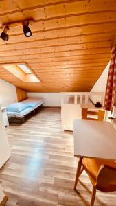 シュナイツロイトにあるHaus Hochhäuslerの木製の天井、テーブルと椅子が備わる客室です。