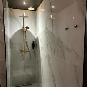 een badkamer met douche en witte marmeren muren bij Insolite Escapade avec Spa privatif in Pacy-sur-Eure +28 foto's