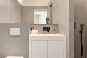 un bagno con un lavandino bianco e uno specchio di IMMOGROOM - Appartements luxueux - 2min du Palais - Vue mer - Clim a Cannes Altre 84 foto
