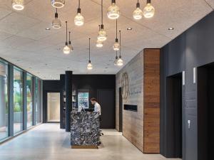 a man standing at a counter in a lobby at Lukullum in Friedrichshafen