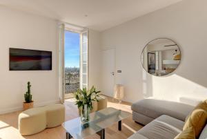 un soggiorno con un divano e un tavolo di IMMOGROOM - Appartements luxueux - 2min du Palais - Vue mer - Clim a Cannes