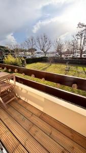a wooden bench on a balcony with a view of a park at Studio face au Bassin d'Arcachon in Andernos-les-Bains
