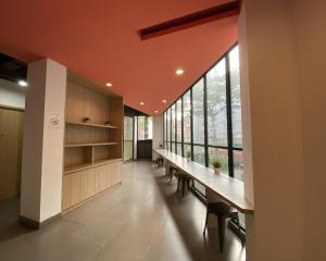 a long hallway with a long table and benches at Maxley Suites Dormitory C1 in Tjilandak