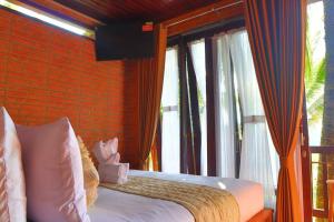a bedroom with a bed and a large window at Abing Dalem - Villa Nangka in Tabanan