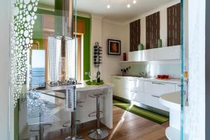 a kitchen with white cabinets and green walls at Salerno e Costiera Amalfitana al Top in Salerno