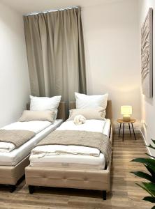 two beds sitting next to each other in a room at Designer City Apartment in Top Lage für 6 Gäste in Karlsruhe