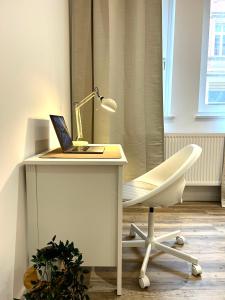 einen Schreibtisch mit Laptop und Lampe in der Unterkunft Designer City Apartment in Top Lage für 6 Gäste in Karlsruhe