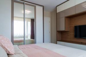 a bedroom with a bed with a mirror and a tv at View in Petrich