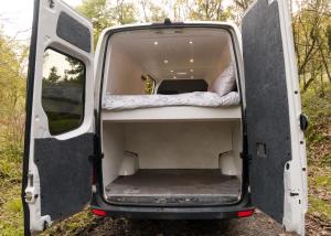 Una furgoneta con las puertas abiertas con una cama en el interior en Viv The VW Campervan - Drive Away, en Neath