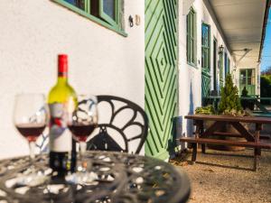 Deanwood Holiday Cottages في Yorkley: زجاجة من النبيذ وكأسين على الطاولة