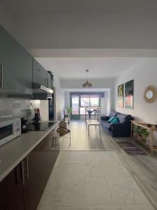 a large kitchen and living room with a blue couch at Macaronesia Home in Santa Cruz de Tenerife
