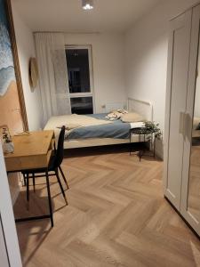 a bedroom with a bed and a table and a desk at Timo Baltic View in Gdańsk