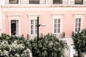 un edificio rosa con alberi di fronte di HO Paseo de Almería a Almería