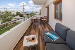 a balcony with a couch and a table at Arodamos Studios & Apts in Kissamos