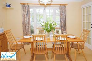 - une salle à manger avec une table et des chaises en bois dans l'établissement Gate House, à Bembridge
