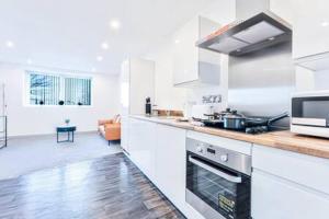 a kitchen with white cabinets and a stove top oven at Stylish 1 Bed Apartment in Wolverhampton in Wolverhampton