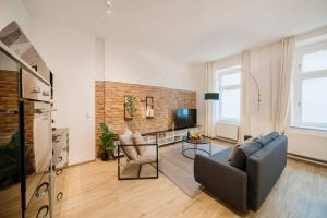uma sala de estar com um sofá e uma televisão em NEW Luxurious Loft in central Berlin BY HOMELY em Berlim