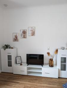 a living room with white cabinets and a television at Ferienwohnung am Theater 2 in Schweinfurt