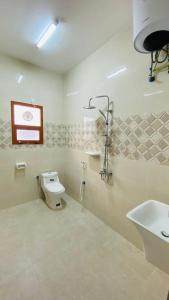 a bathroom with a toilet and a sink at Haima Hotel in Haymāʼ