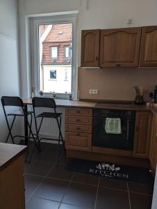a kitchen with a stove and a table with chairs at Ferienwohnung am Theater 2 in Schweinfurt