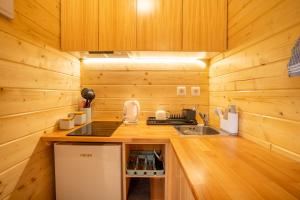 - une cuisine avec des murs en bois et un comptoir avec un évier dans l'établissement Garden bungalow, à São Vicente