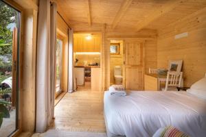 - une chambre dans une cabane en rondins avec un lit dans l'établissement Garden bungalow, à São Vicente