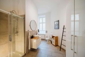 a bathroom with a sink toilet and a mirror at NEW Urban Oasis - Sleek Apartment BY HOMLEY in Berlin