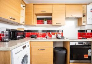 a kitchen with a washer and a sink and a dishwasher at The Dartford Lodge - Free Parking in Kent +18 photos