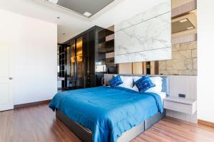 a bedroom with a blue bed with a marble wall at Luxury 31st Top Floor Condo with Swimming Pool in Chiang Mai