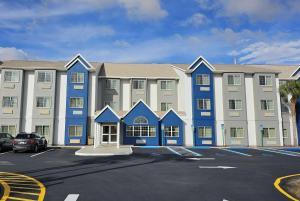 un grand bâtiment bleu et blanc avec un parking dans l'établissement Microtel Inn & Suites by Wyndham Bushnell, à Bushnell