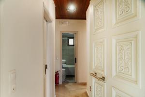 een gang met een deur en een badkamer met een bad bij Dada's Cottage in Argyrádes