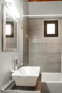 een badkamer met een witte wastafel en een bad bij Dada's Cottage in Argyrádes