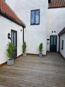 a patio with two potted plants in front of a building at No 8 Plants Yard Modern studio in Worksop in Worksop