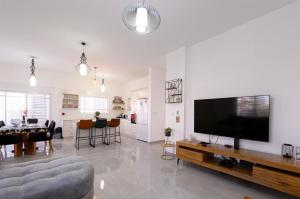 uma sala de estar com uma grande televisão de ecrã plano em וילת אורית בגלבוע 