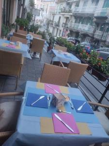 einen blauen Tisch mit Servietten und Küchenutensilien darauf in der Unterkunft Hotel Caporal in Minori