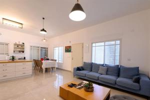 sala de estar con sofá azul y mesa en וילת אורית בגלבוע, 