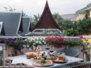 una mesa con comida y copas de vino en el balcón en Sofitel Krabi Phokeethra Golf and Spa Resort en Klong Muang Beach