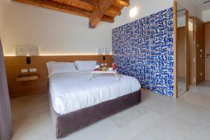 a bedroom with a bed with a blue and white wall at Borgo Giallonardo Wine Relais in Realmonte