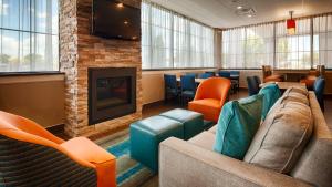 a waiting room with a couch and chairs and a fireplace at Best Western Hartford Hotel and Suites in Hartford